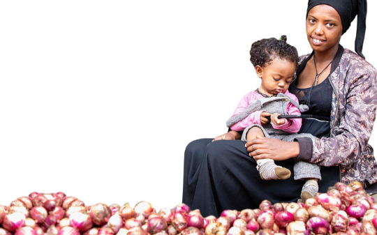 Ethiopian onion vendor holding a child